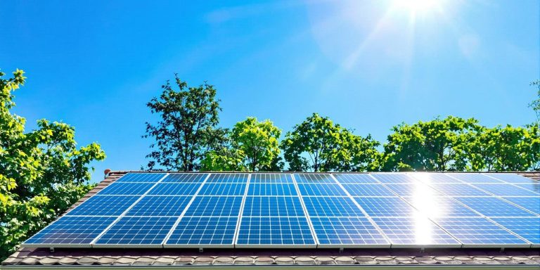 Rooftop solar panels under bright sun and blue sky