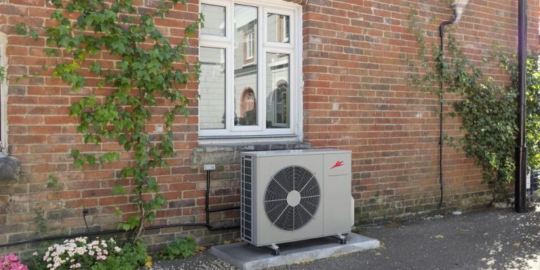 Air source heat pump attached to old brick home.